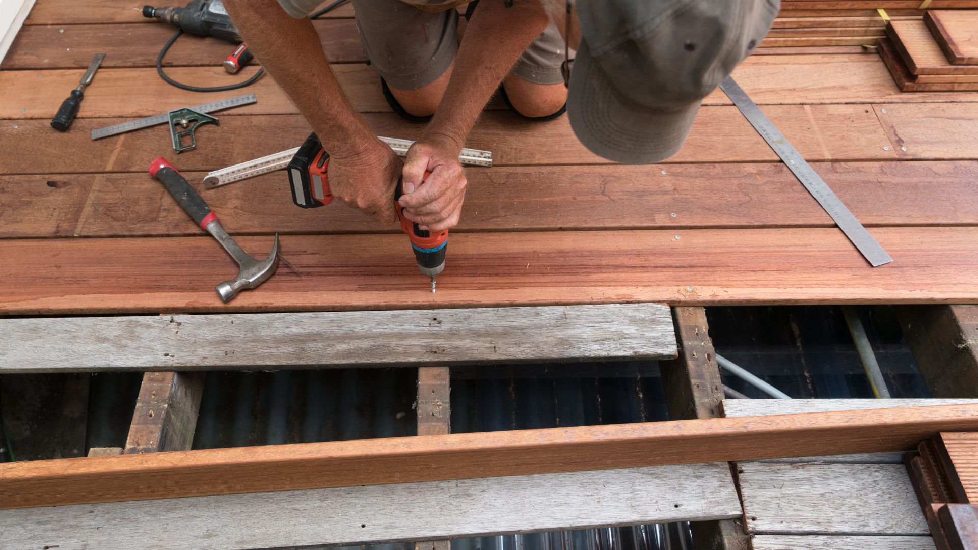 A man working on a wooden floor with tools